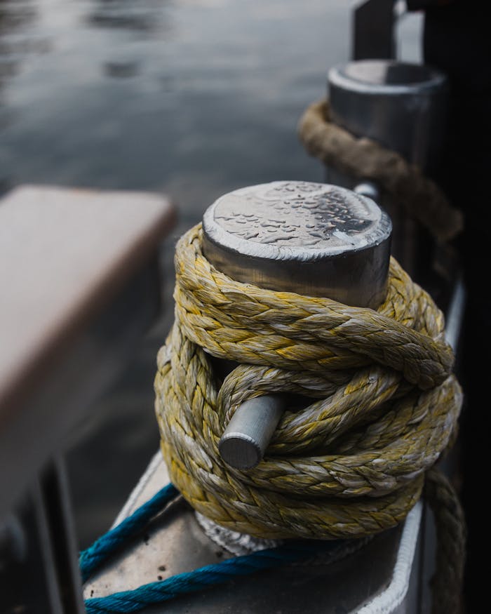 Detailed shot of a wet mooring post with rope on a boat, showcasing marine equipment.